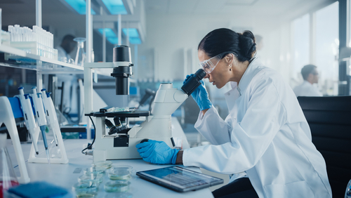 Medical,Development,Laboratory:,Caucasian,Female,Scientist,Looking,Under,Microscope,,Analyzes